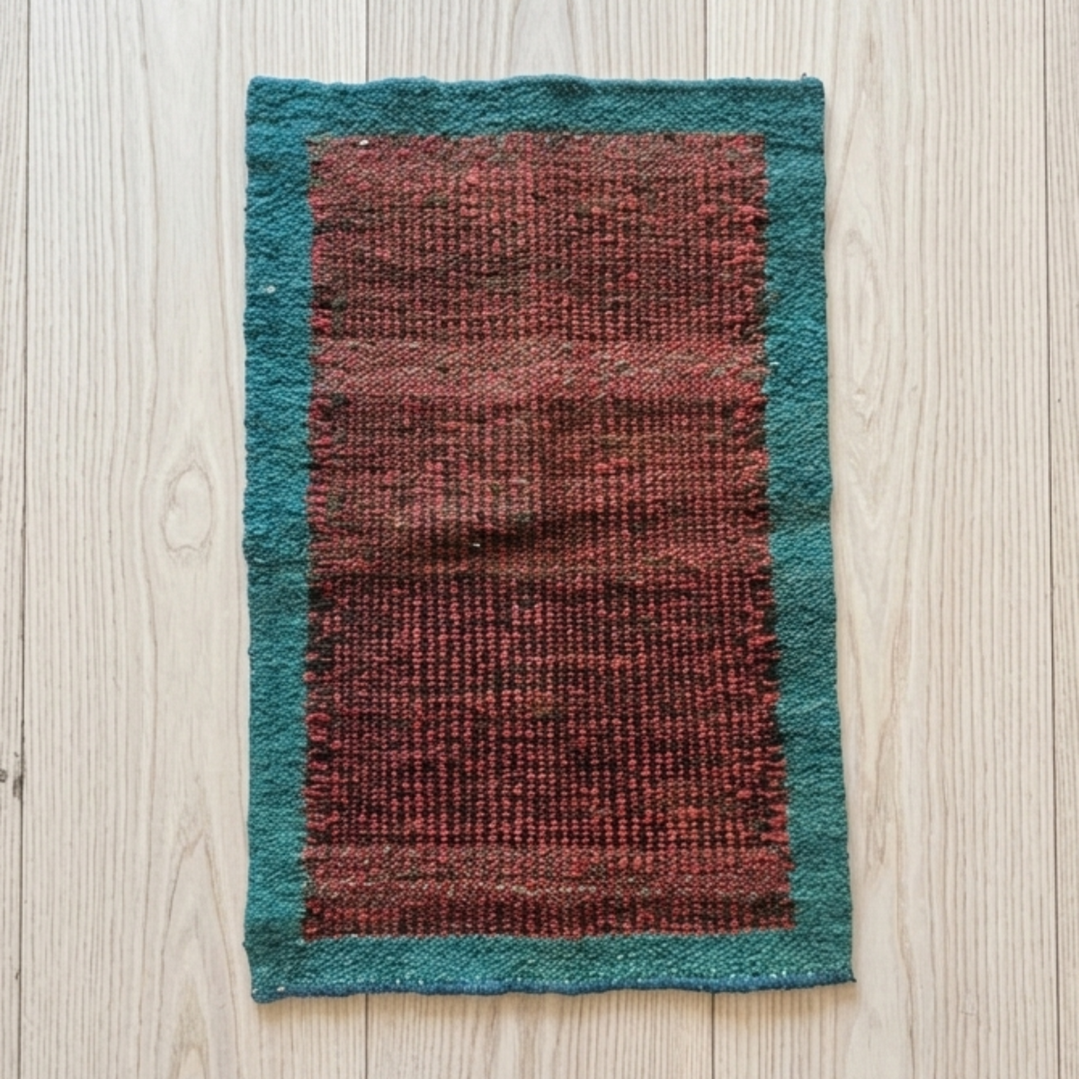 Textured fabric with red and green pattern on a wooden surface